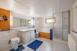 This bright and functional bathroom features a spacious vanity with ample storage, a comfortable toilet, and a separate shower stall.