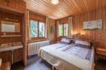 Experience rustic charm in this cozy bedroom featuring warm wood paneling throughout.