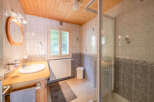 This charming bathroom features a wooden vanity with a white sink and a sleek chrome faucet, complemented by a large oval mirror with a wooden frame.