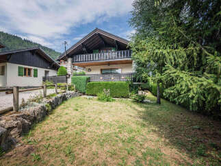 Charming alpine chalet with a spacious balcony offering scenic mountain views.