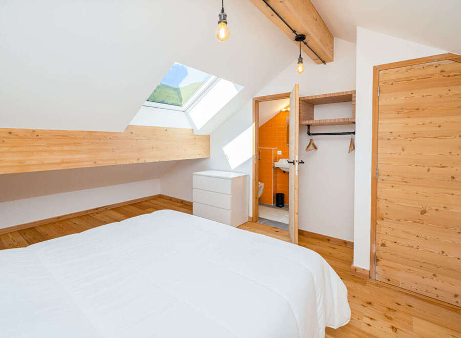 Experience cozy attic living in this charming bedroom featuring a sloped ceiling with a skylight offering picturesque views.