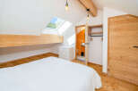 Experience cozy attic living in this charming bedroom featuring a sloped ceiling with a skylight offering picturesque views.