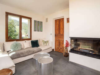 Experience breathtaking mountain views from this cozy living room, featuring a comfortable sectional sofa and a modern fireplace.