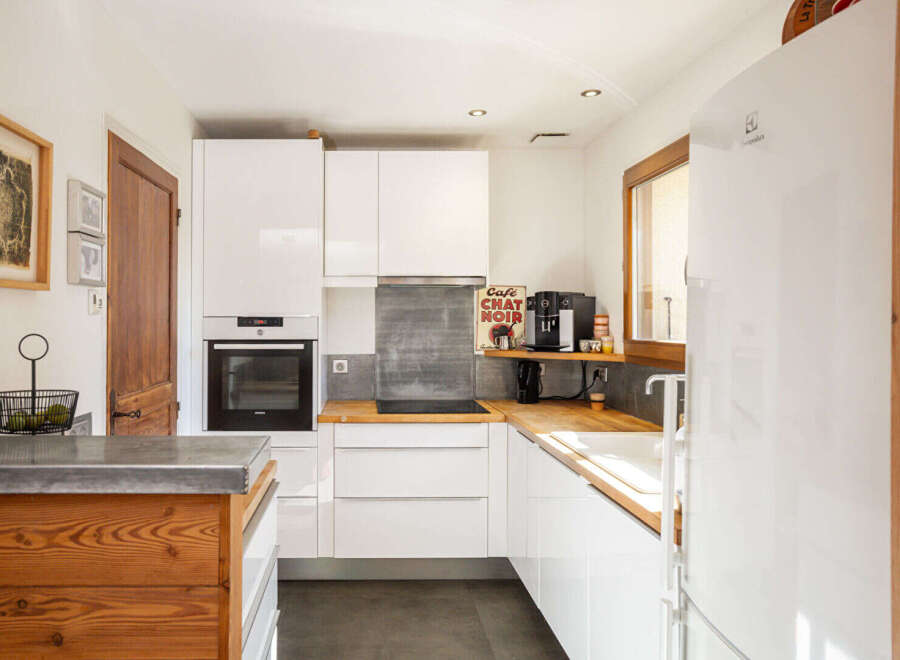 Discover this modern and functional kitchen, featuring sleek white cabinetry and a built-in oven.