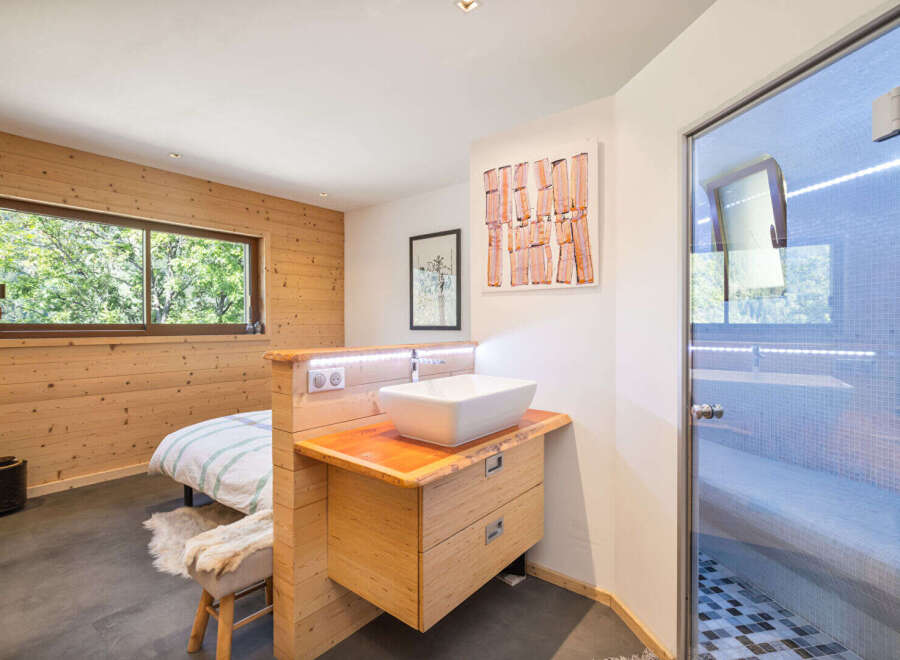 Experience ultimate relaxation in this modern bedroom featuring a unique en-suite bathroom with a vessel sink and a luxurious glass-enclosed shower.