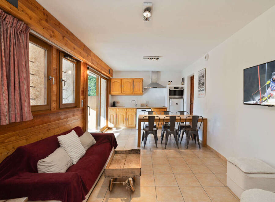 This charming mountain retreat features a cozy living area with a plush sofa, perfect for relaxing after a day on the slopes.