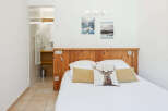 Experience comfort and style in this charming bedroom featuring a rustic wooden headboard and a unique deer-themed accent pillow.