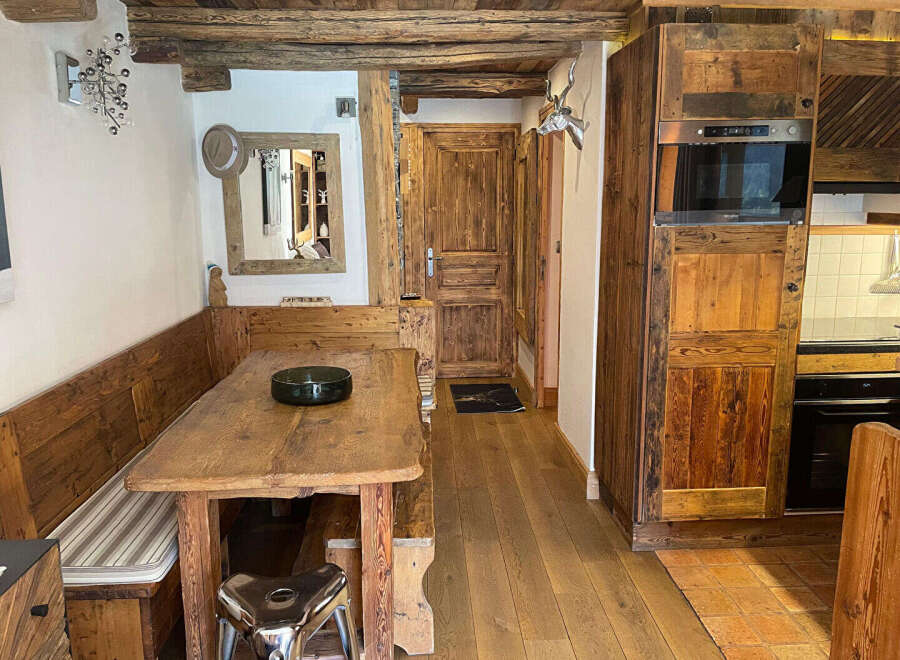Experience rustic charm in this cozy dining area, featuring a wooden banquette and a sturdy wooden table perfect for family meals.