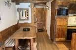 Experience rustic charm in this cozy dining area, featuring a wooden banquette and a sturdy wooden table perfect for family meals.