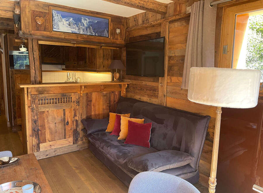 Experience rustic charm in this cozy mountain retreat, featuring a warm wooden interior and a comfortable living area.