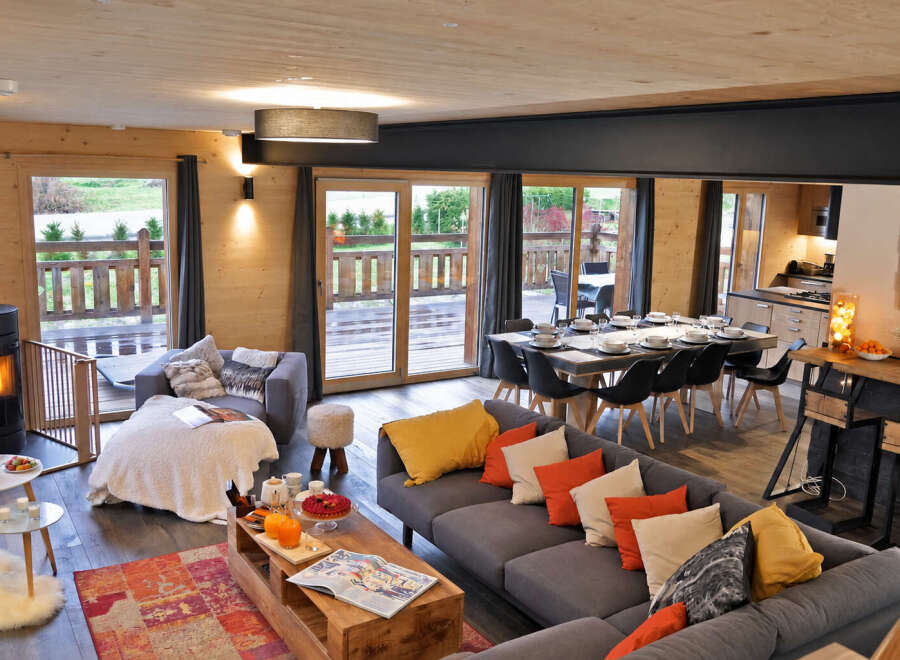 Experience modern mountain living in this stunning open-concept chalet, featuring a spacious living and dining area perfect for gatherings.