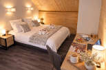 Experience cozy mountain living in this charming hotel room, featuring a comfortable queen-sized bed adorned with plush linens and decorative pillows.