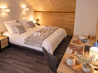 Experience cozy mountain living in this charming hotel room, featuring a comfortable queen-sized bed adorned with plush linens and decorative pillows.