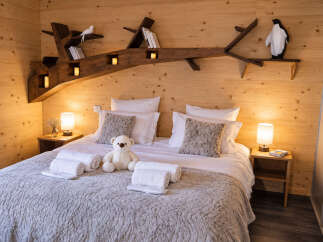 Experience cozy comfort in this charming bedroom, featuring a plush queen-sized bed adorned with soft linens and decorative pillows.