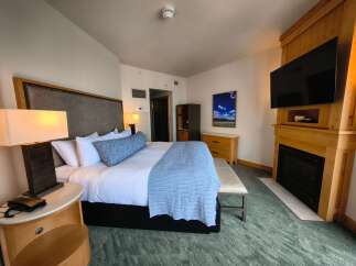 Experience ultimate comfort in this luxurious hotel room featuring a king-sized bed with plush bedding and decorative pillows.