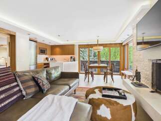 Experience modern living in this beautifully appointed condo, featuring a sleek kitchen with wood cabinetry and stainless steel appliances.