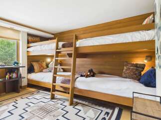 This charming bedroom features a space-saving bunk bed with warm wood finishes, perfect for a family or guest room.