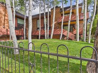 Nestled amongst mature aspen trees, this stunning multi-level home offers a unique architectural design with warm brick exteriors and striking wood accents.