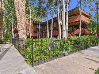 Charming brick building nestled amongst mature trees, offering a serene and private setting.
