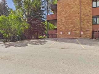 Discover this charming property featuring a well-maintained brick building surrounded by lush greenery and mature trees.