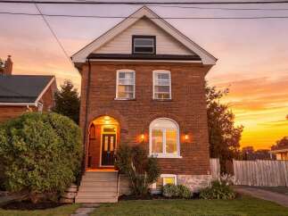 Charming brick home with a welcoming arched entryway and a beautiful arched window, perfect for enjoying the sunset.