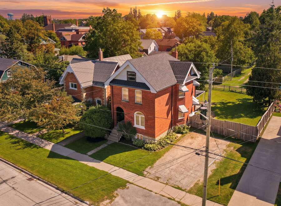 Discover this charming brick home bathed in the warm glow of a sunset.