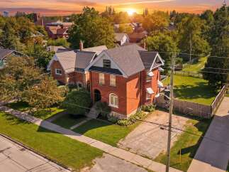 Discover this charming brick home bathed in the warm glow of a sunset.