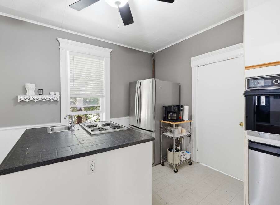 Discover this charming kitchen featuring a sleek stainless steel refrigerator and a convenient coffee station.