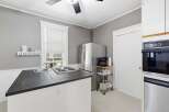 Discover this charming kitchen featuring a sleek stainless steel refrigerator and a convenient coffee station.