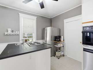 Discover this charming kitchen featuring a sleek stainless steel refrigerator and a convenient coffee station.