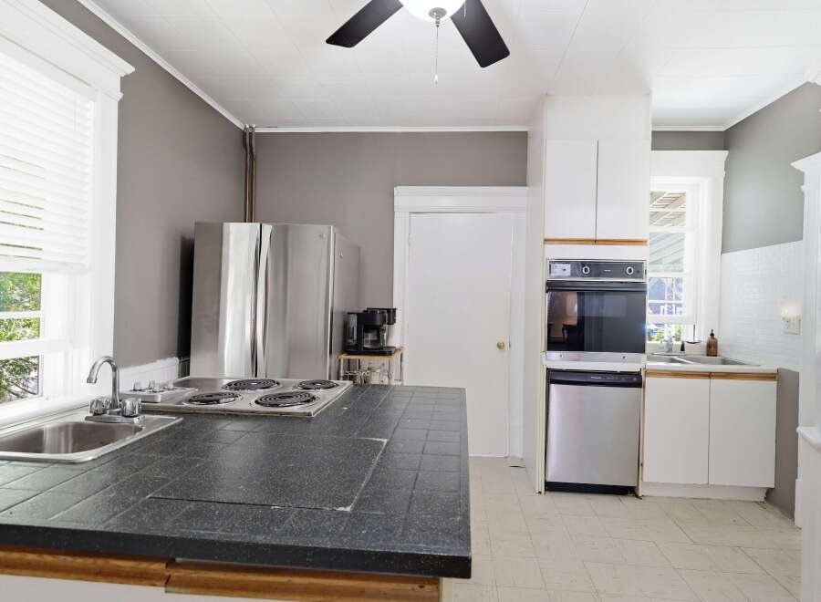 This kitchen features a spacious island with a built-in stovetop and sink, perfect for meal preparation.