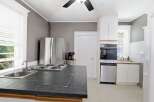 This kitchen features a spacious island with a built-in stovetop and sink, perfect for meal preparation.