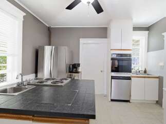 This kitchen features a spacious island with a built-in stovetop and sink, perfect for meal preparation.