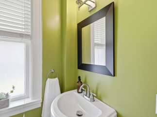 Brighten your space with this charming bathroom featuring a vibrant lime green accent wall.