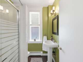 Bright and inviting bathroom featuring a sleek pedestal sink with a modern faucet and a decorative wall mirror.