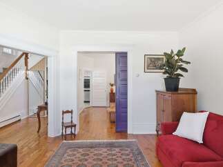 Step into this charming home featuring a grand staircase and an inviting living area.