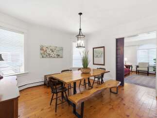 This charming dining room features a rustic live-edge dining table with a matching bench and wooden chairs, perfect for intimate gatherings.