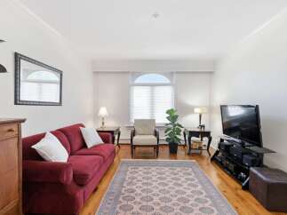 Step into this inviting living room, featuring a plush red sofa perfect for relaxation and a decorative rug that adds warmth and style.