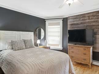 Experience rustic charm in this inviting bedroom, featuring a striking reclaimed wood accent wall that adds warmth and character.