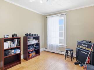 This room is perfect for a musician or photographer, featuring a dedicated space for gear storage with multiple bookshelves.