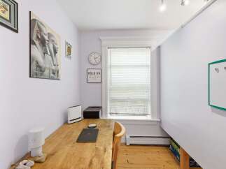 This home office space features a rustic wooden desk equipped with a laptop and printer, perfect for productivity.