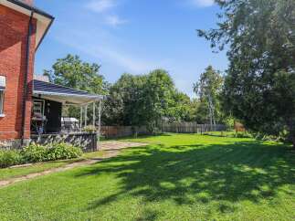 Discover this charming property featuring a classic red brick exterior and a welcoming covered porch, perfect for enjoying your morning coffee.