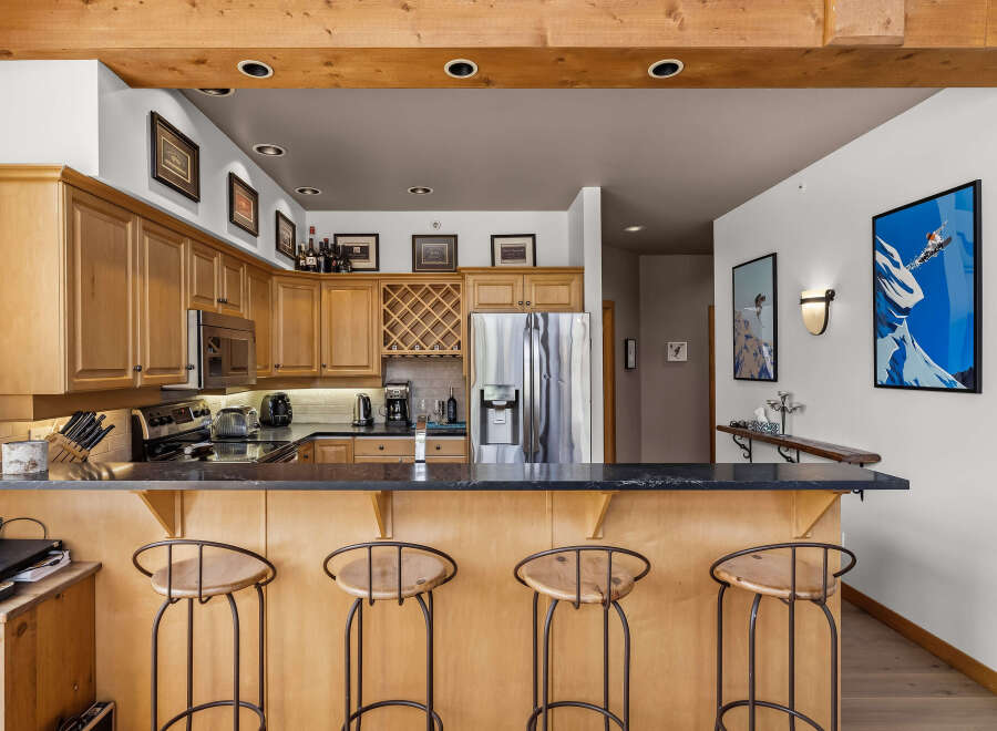 This stunning kitchen features beautiful light wood cabinetry and a spacious granite-topped island, perfect for entertaining.