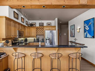 This stunning kitchen features beautiful light wood cabinetry and a spacious granite-topped island, perfect for entertaining.