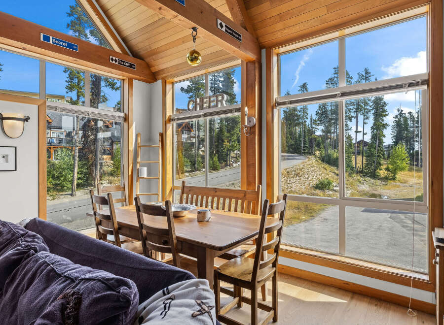 Experience breathtaking mountain views from this charming dining area, featuring a rustic wooden table and chairs perfect for family meals.