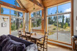 Experience breathtaking mountain views from this charming dining area, featuring a rustic wooden table and chairs perfect for family meals.