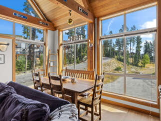 Experience breathtaking mountain views from this charming dining area, featuring a rustic wooden table and chairs perfect for family meals.