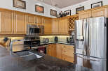 This modern kitchen boasts sleek stainless steel appliances, including a double-door LG refrigerator with an ice dispenser, and a built-in microwave.