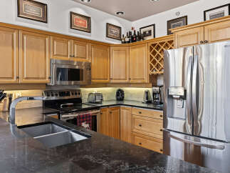 This modern kitchen boasts sleek stainless steel appliances, including a double-door LG refrigerator with an ice dispenser, and a built-in microwave.