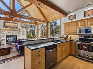 Experience the ultimate mountain retreat in this stunning home featuring a vaulted wood-beamed ceiling and a cozy stone fireplace.